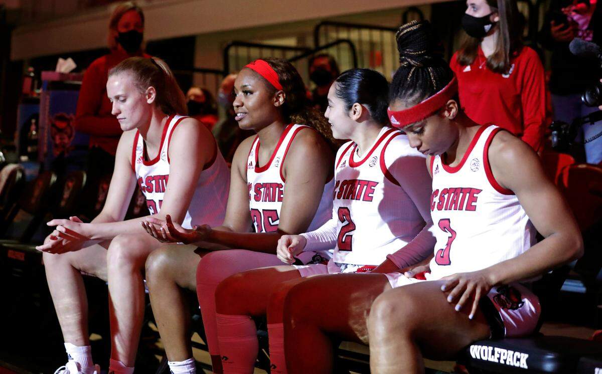 From left, N.C. State’s Elissa Cunane (33), Kayla Jones (25), Raina Perez (2) and Kai Crutchfield (3) wait to be introduced before N.C. State’s game against Duke at Reynolds Coliseum in Raleigh, N.C., Sunday, January 16, 2022.