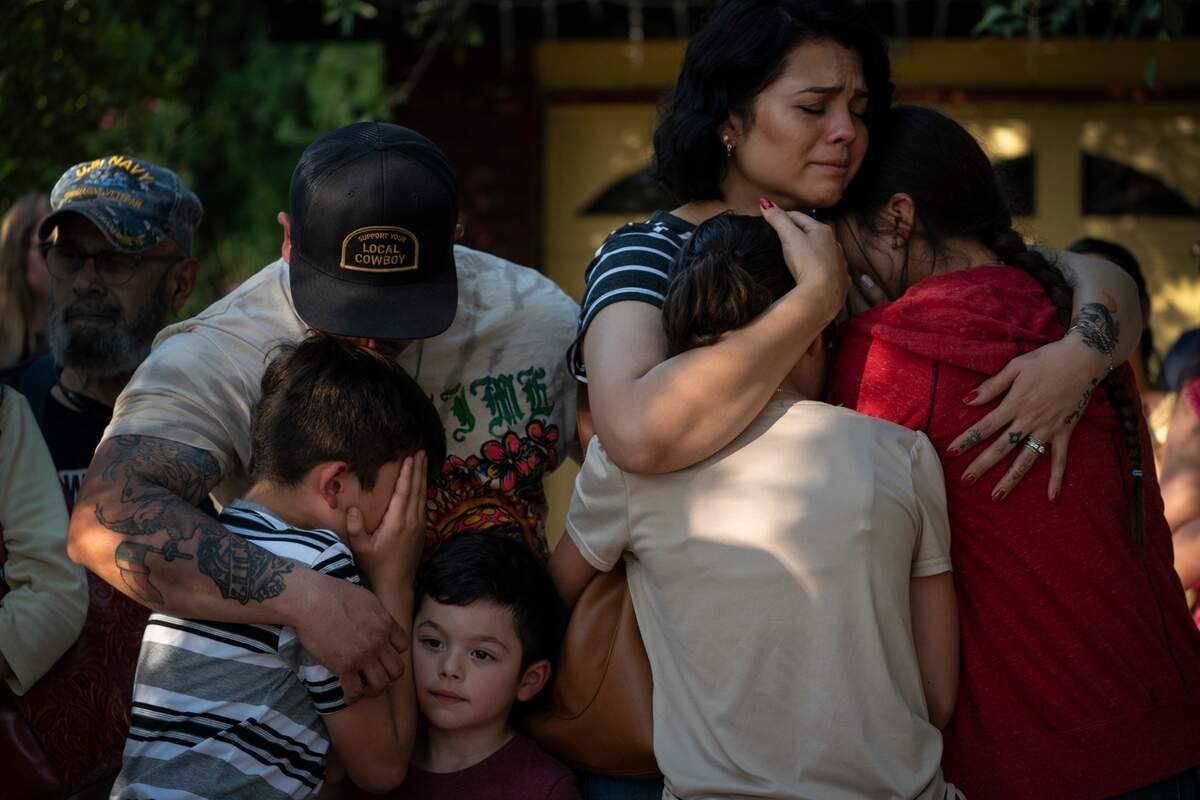 Raquel Martinez, comforts her daughters while her husband, Daniel Martinez, comforts their sons outside Robb Elementary School on May 26, 2022, in Uvalde, Texas. Martinez said her children are scared.