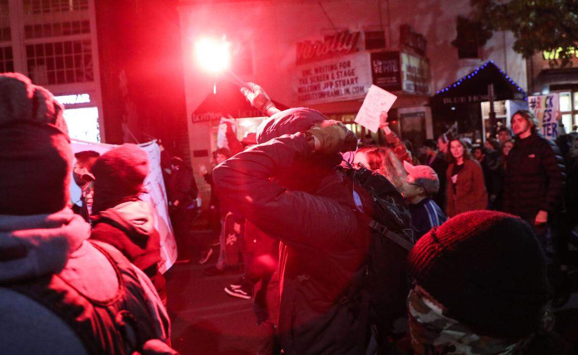 A protester carries a flare while marching on Franklin Street Monday night in protest of UNC’s recommendation to house Silent Sam inside a $5.3 million history and education center, to be built at the edge of campus.