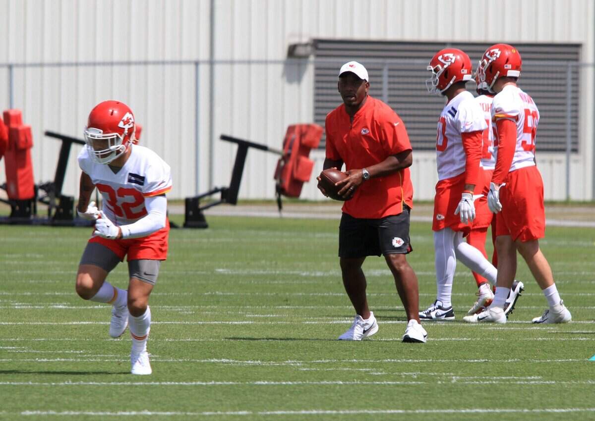 Defensive backs coach Dave Merritt looks to throw the ball in a drill with safety Tyrann Mathieu at Kansas City Chiefs practice June 11. Merritt, a Raleigh native, went to Millbrook High and played football at N.C. State.
