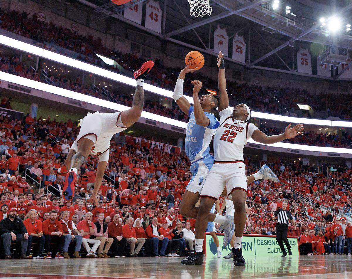 North Carolina's Jarin Stevenson drives to the basket against N.C. State's Darrion Williams and Ven-Allen Lubin in first half action. Williams left the game with an injury to the face after hitting the floor hard, but returned to action before the half.