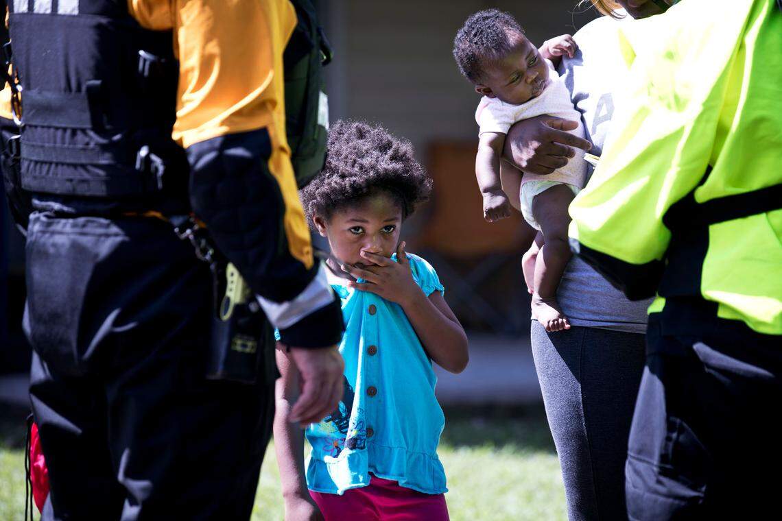 Zoey Smith, 4, stands with her mother Krystale and 2-month-old sister Hailee while Krystale receives information about nearby shelters from New York Urban Search and Rescue team members at the Heritage at Fort Bragg Apartments in Spring Lake, N.C., Tuesday Sept. 18, 2018. The family has been living out of their car since their ground floor apartment flooded earlier this week.