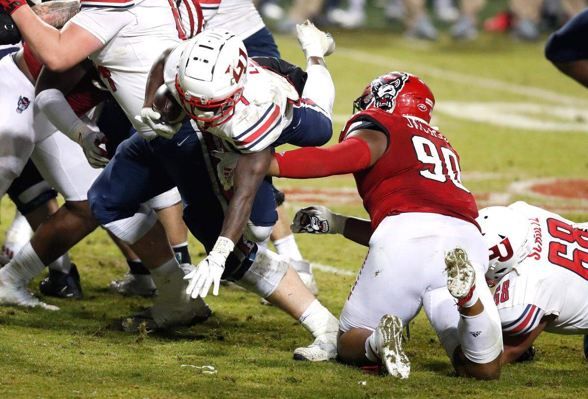 N.C. State defensive end Savion Jackson (90) stops Liberty running back Shedro Louis (1) for a gain of only one yard during the second half of N.C. State’s 15-14 victory over Liberty at Carter-Finley Stadium in Raleigh, N.C., Saturday, Nov. 21, 2020.