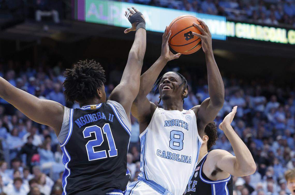 North Carolina's Caleb Wilson (8) shoots as Duke’s Patrick Ngongba II (21) and Cameron Boozer (12) defend during the first half of Duke’s game against UNC at the Dean E. Smith Center in Chapel Hill, N.C., Saturday, Feb. 7, 2026.