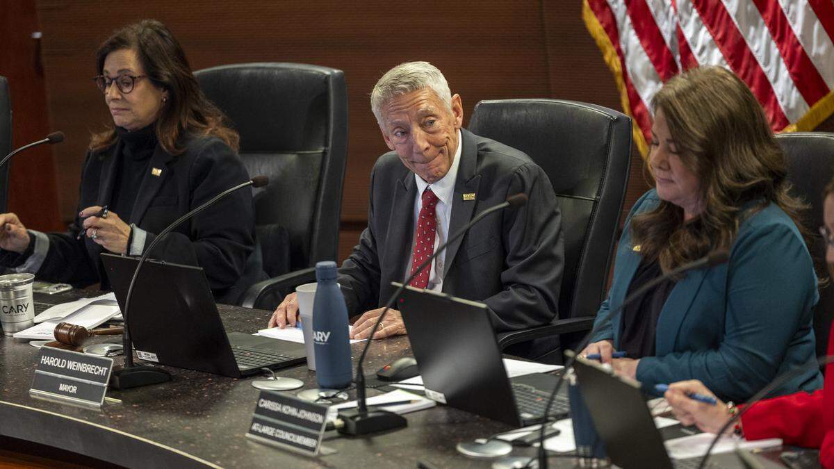 Cary Mayor Harold Weinbrecht, center, leads a Cary Town Council meeting at Cary Town Hall on Thursday, Dec. 11, 2025.
