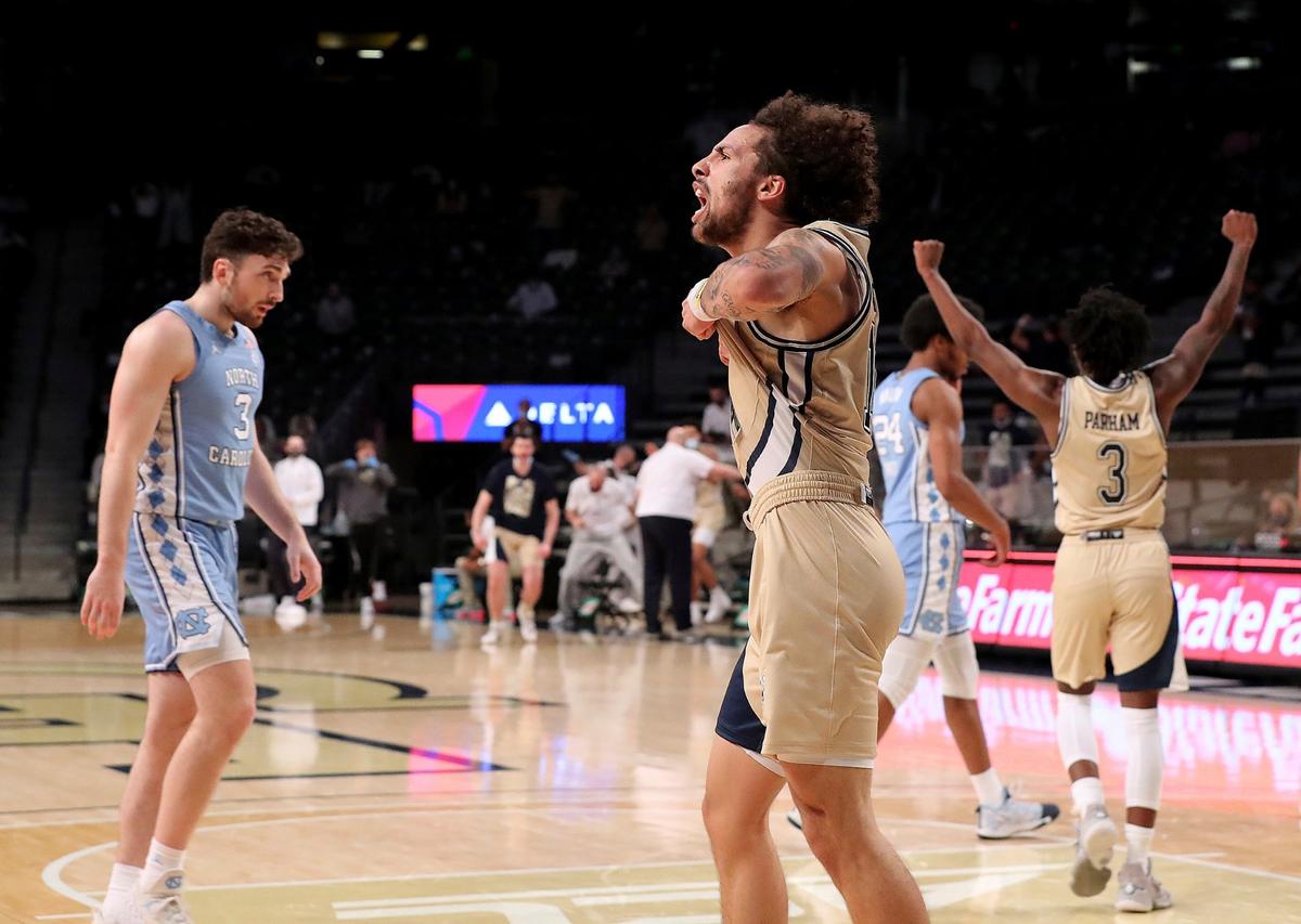 Georgia Tech guards Jose Alvarado, front, and Bubba Parham react near North Carolina’s Andrew Platek, left, after Georgia Tech’s win in an NCAA college basketball game Wednesday, Dec. 30, 2020, in Atlanta.