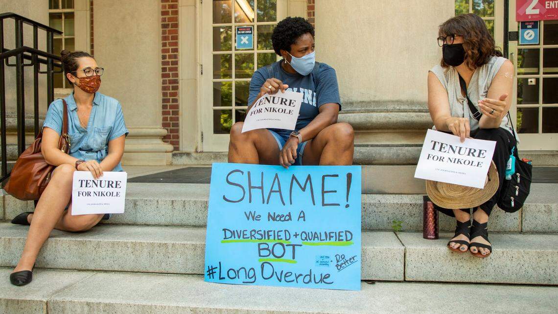 From left, Sarah Miles, a current graduate student, Carol Shirley, an alumni, and Deborah Dwyer, a doctoral candidate, gather on the steps of Carroll Hall, where the UNC-Chapel Hill Hussman School of Journalism and Media is located, before the university’s Board of Trustees is scheduled to vote on tenure for distinguished journalist Nikole Hannah-Jones, on Wednesday, Jun. 30, 2021, in Chapel Hill, N.C.