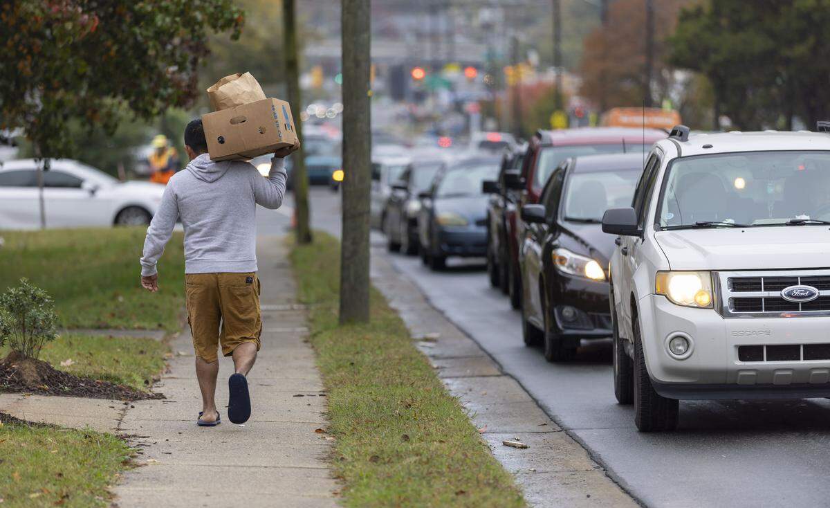 A recipient of the Emanuel Food Pantry at Durham Presbyterian Church, walks home with a box of groceries after visiting the weekly pantry on Roxboro Street on Wednesday, Oct. 29, 2025 in Durham, N.C.