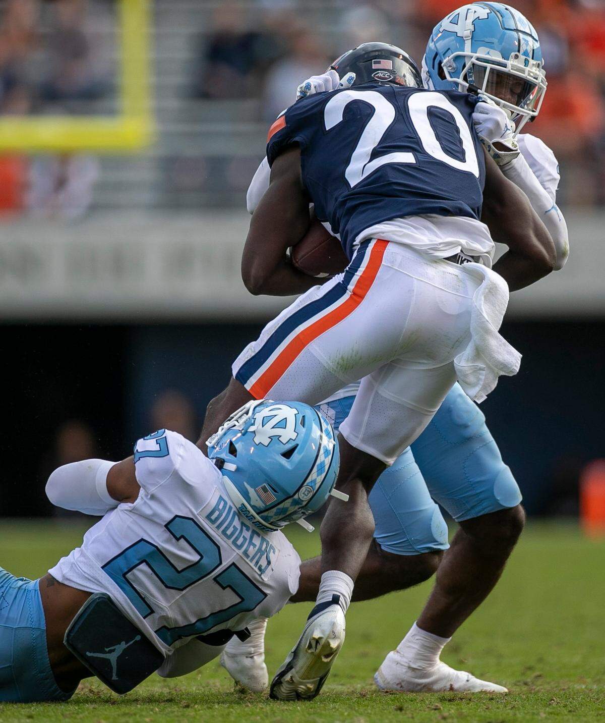 North Carolina’s Giovanni Biggers (27) and Storm Duck (3) work together to stop Virginia running back Xavier Brown (20) after a four-yard gain in the fourth quarter on Saturday, November 5, 2022 at Scott Stadium in Charlottesville, Va.