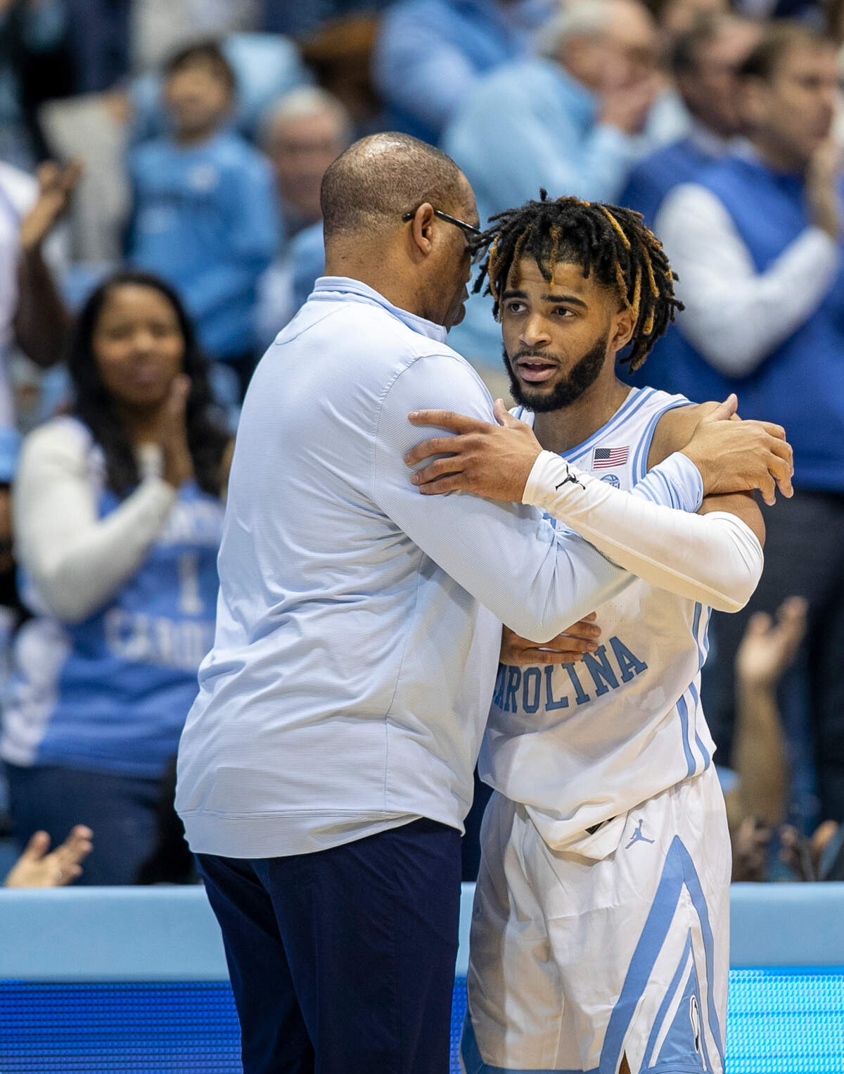 North Carolina coach Hubert Davis embraces R.J. Davis (4) as he comes out of the game in the closing minutes after scoring 13 points against Notre Dame on Saturday, January 7, 2023 at the Smith Center in Chapel Hill, N.C.