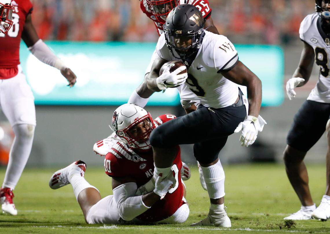 N.C. State defensive end Savion Jackson (90) tackles Wake Forest running back Kenneth Walker III (9) during the first half of N.C. State’s game against Wake Forest at Carter-Finley Stadium in Raleigh, N.C, Saturday, Sept. 19, 2020.