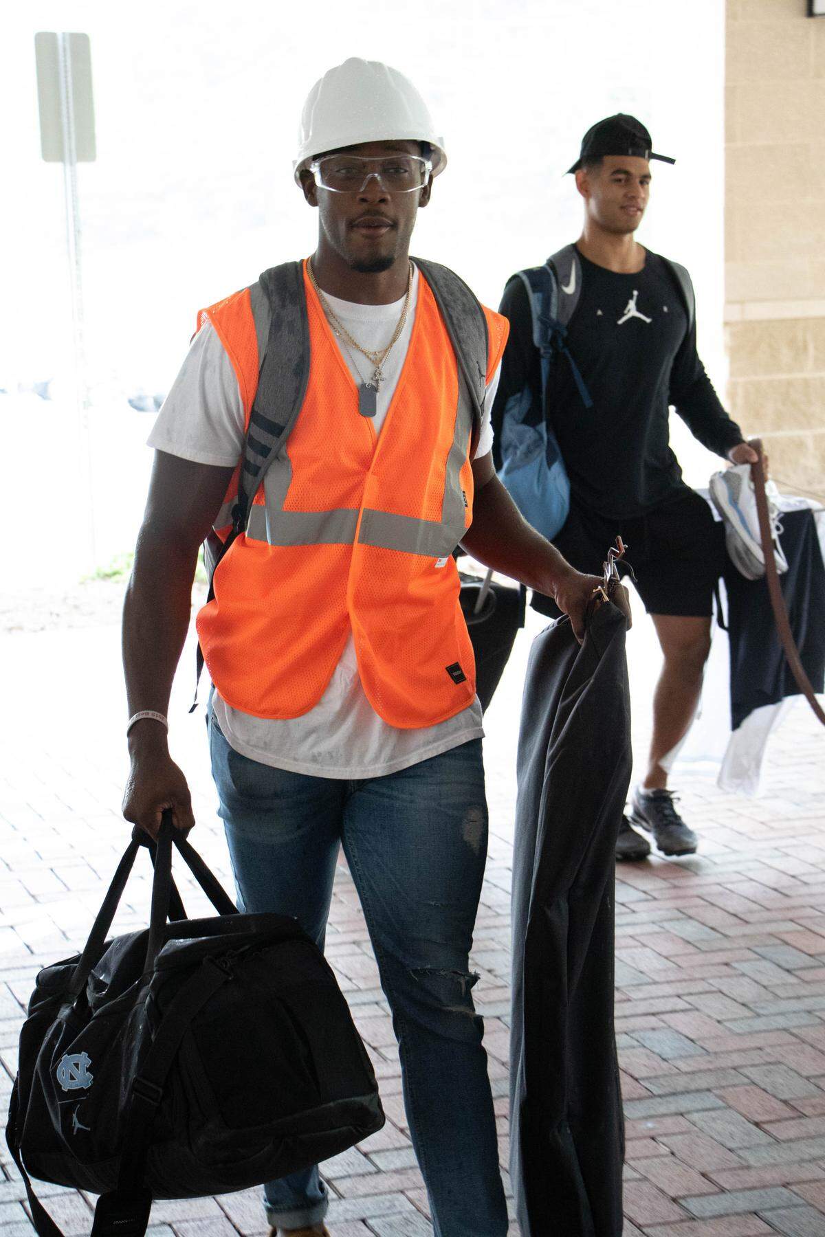 UNC cornerback Patrice Rene wears a hard hat with an orange vest and goggles he purchased from Walmart and Lowe’s to move-in day for fall camp.