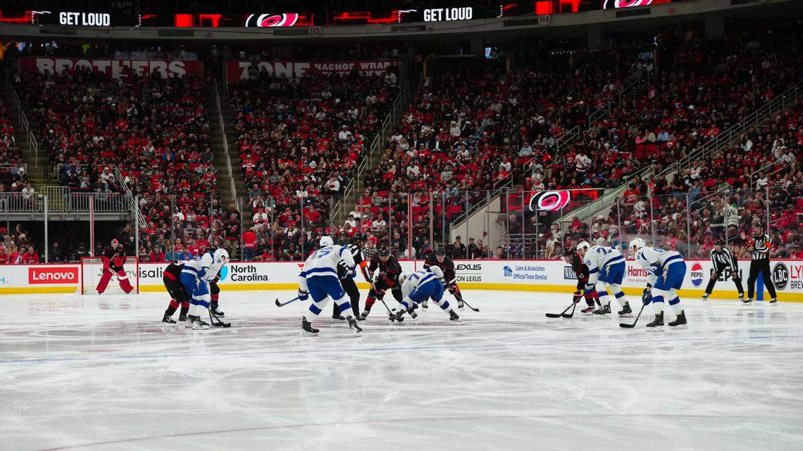 Carolina Hurricanes center Sebastian Aho (20) and Tampa Bay Lightning center Anthony Cirelli (71) take the opening face off of the season during the first period at Raleigh’s Lenovo Center on Friday, October 11.