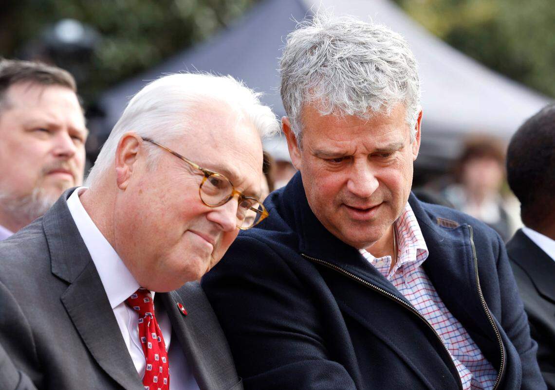 N.C. State Chancellor Randy Woodson, left, talks with athletics director Boo Corrigan during a ceremony to unveil a statue of N.C. State’s David Thompson outside Reynolds Coliseum in Raleigh, N.C., Wednesday, Dec. 6, 2023.