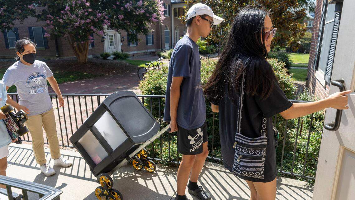 University of North Carolina rising junior Clarisse Sobremonte of Asheville, N.C., opens the door to Alderman Residence Hall as her brother Jason Sobremonte and mother Cathy Sobremonte help move her into her dormitory for the upcoming school year on Thursday, August 4, 2022 in Chapel Hill , N.C. Sobremonte arrived on campus early for training as an office assistant in the housing department.