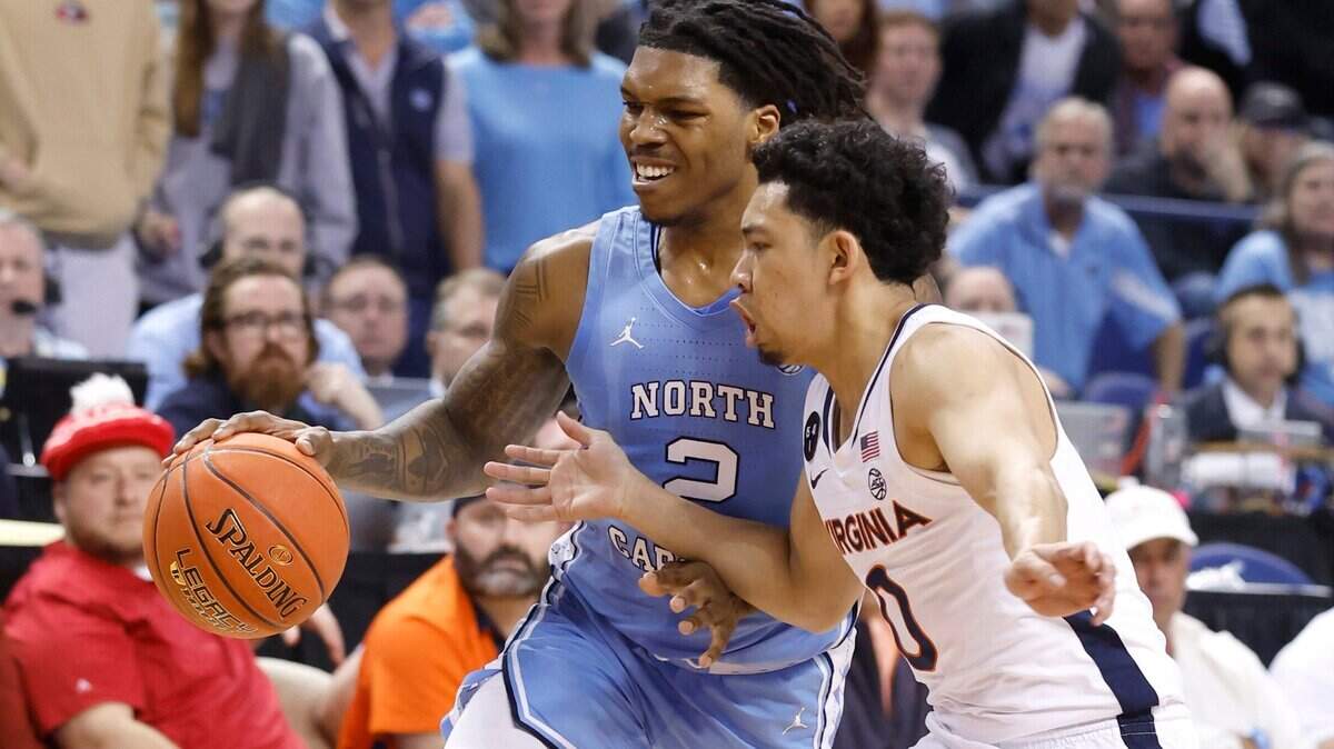 North Carolina’s Caleb Love (2) drives to the basket while defended by Virginia’s Kihei Clark (0) during the first half of UNC’s game against Virginia in the quarterfinals of the ACC Men’s Basketball Tournament in Greensboro, N.C., Thursday, March 9, 2023.