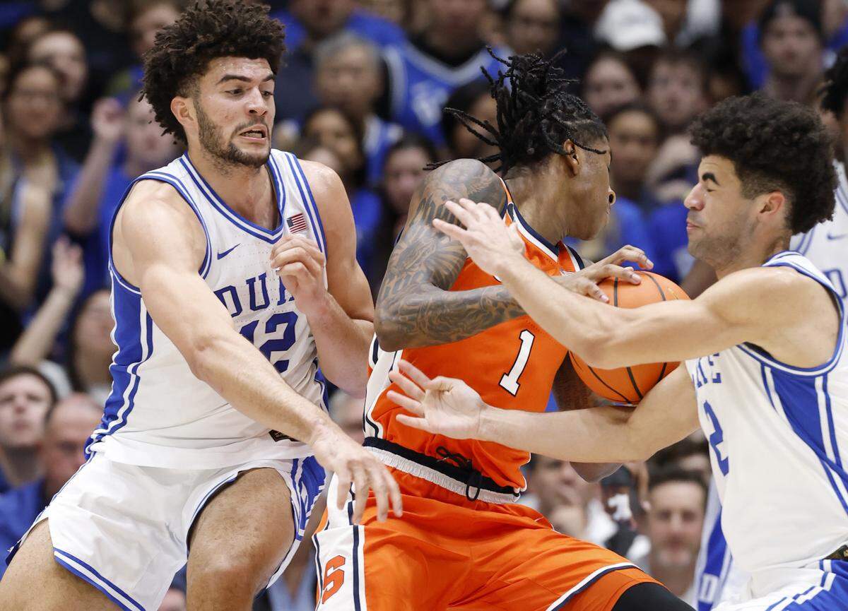 Duke’s Cameron Boozer (12) and Cayden Boozer (2) defend Syracuse's Donnie Freeman (1) during the first half of Duke’s game against Syracuse at Cameron Indoor Stadium in Durham, N.C., Monday, Feb. 16, 2026.