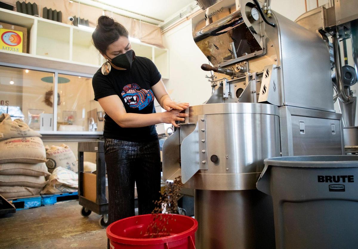 Areli Barrera de Grodski, co-owner of Cocoa Cinnamon and Little Waves Coffee Roasters, empties freshly roasted coffee beans into a container, on Wednesday, Mar. 31, 2021, in Durham, N.C.