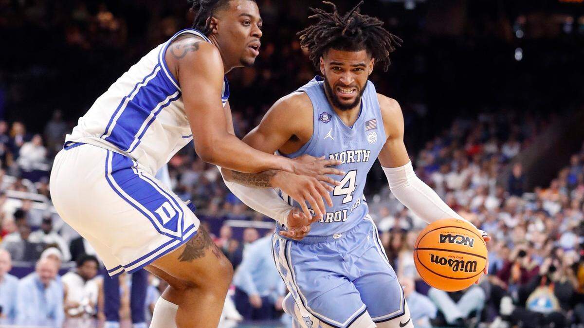 North Carolina’s R.J. Davis (4) drives around Dukes Trevor Keels (1) during the first half of Dukes game against UNC in the Final Four at Caesars Superdome in New Orleans, La., Saturday, April 2, 2022.