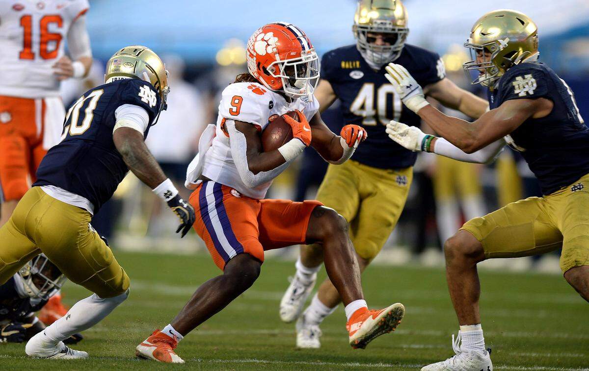 Clemson Tigers running back k Travis Etienne, center, rushes for yardage against the Notre Dame defense during second quarter action at Bank of America Stadium on Saturday, December 19, 2020 in Charlotte, NC. The Clemson Tigers and Notre Dame Fighting Irish faced off in the ACC Championship game.