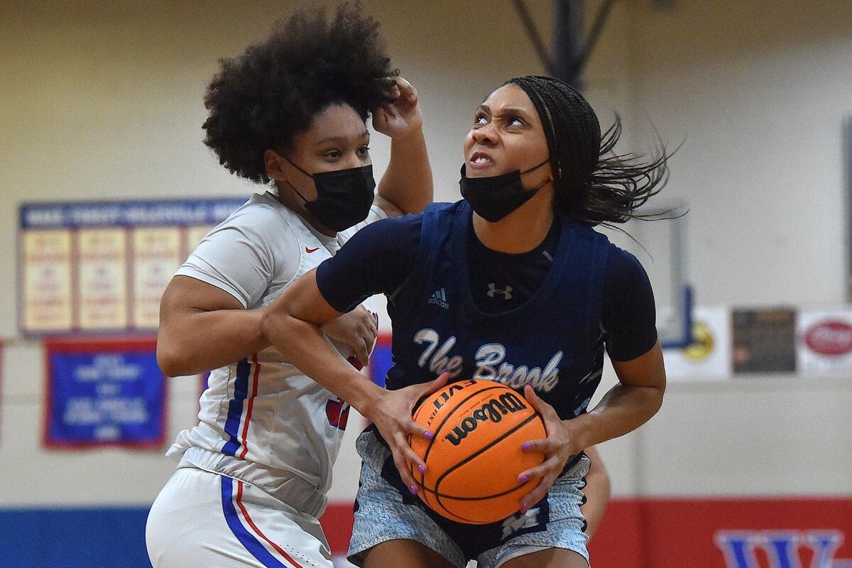 Millbrook’s Corrie McLaughlin (20) looks to shoot against Wake Forest’s Jaidyn Kavadias (31) during the second half. The Wake Forest Cougars and the Millbrook Wildcats met in a basketball game in Wake Forest, N.C. on February 8, 2022.