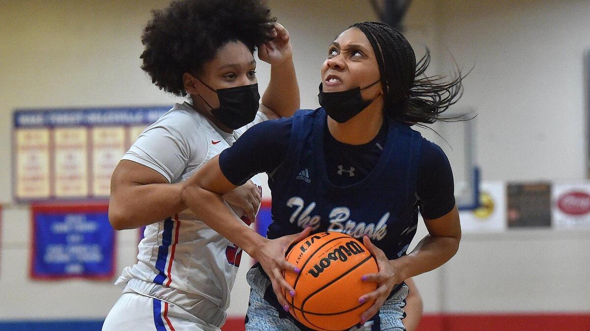 Millbrook’s Corrie McLaughlin (20) looks to shoot against Wake Forest’s Jaidyn Kavadias (31) during the second half. The Wake Forest Cougars and the Millbrook Wildcats met in a basketball game in Wake Forest, N.C. on February 8, 2022.