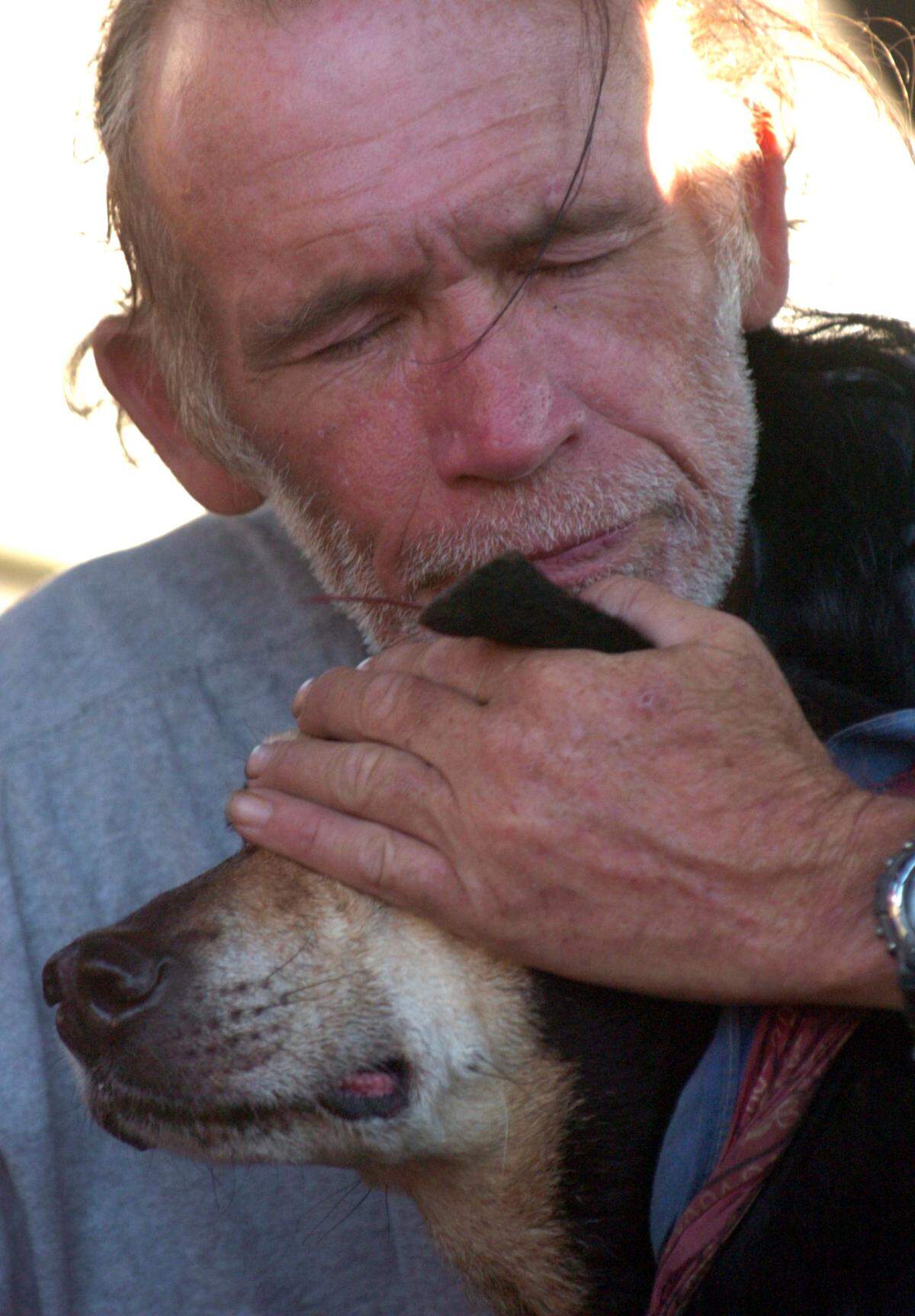 Randy Feike, 53, hugs his dog Athena after they were rescued by a joint 82nd Airborne and Coast Guard Ice Boat crew Tuesday Sept. 6, 2005.