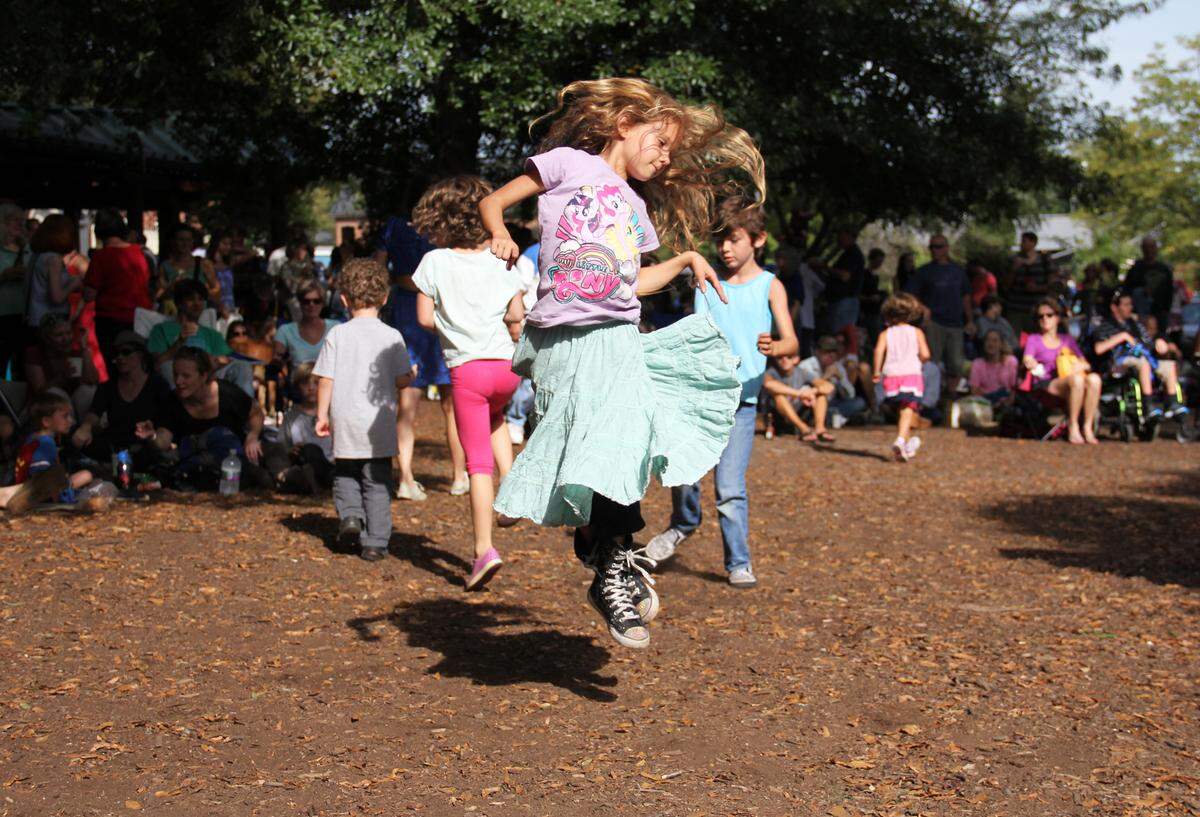 Kristah Bartee, 7, of Durham leaps to the band Triple Fret during the Carrboro Music Festival on Sunday, Sept. 28. 2014. Over 180 acts played for free across downtown Carrboro from 1 p.m. to midnight during the 17th annual festival.