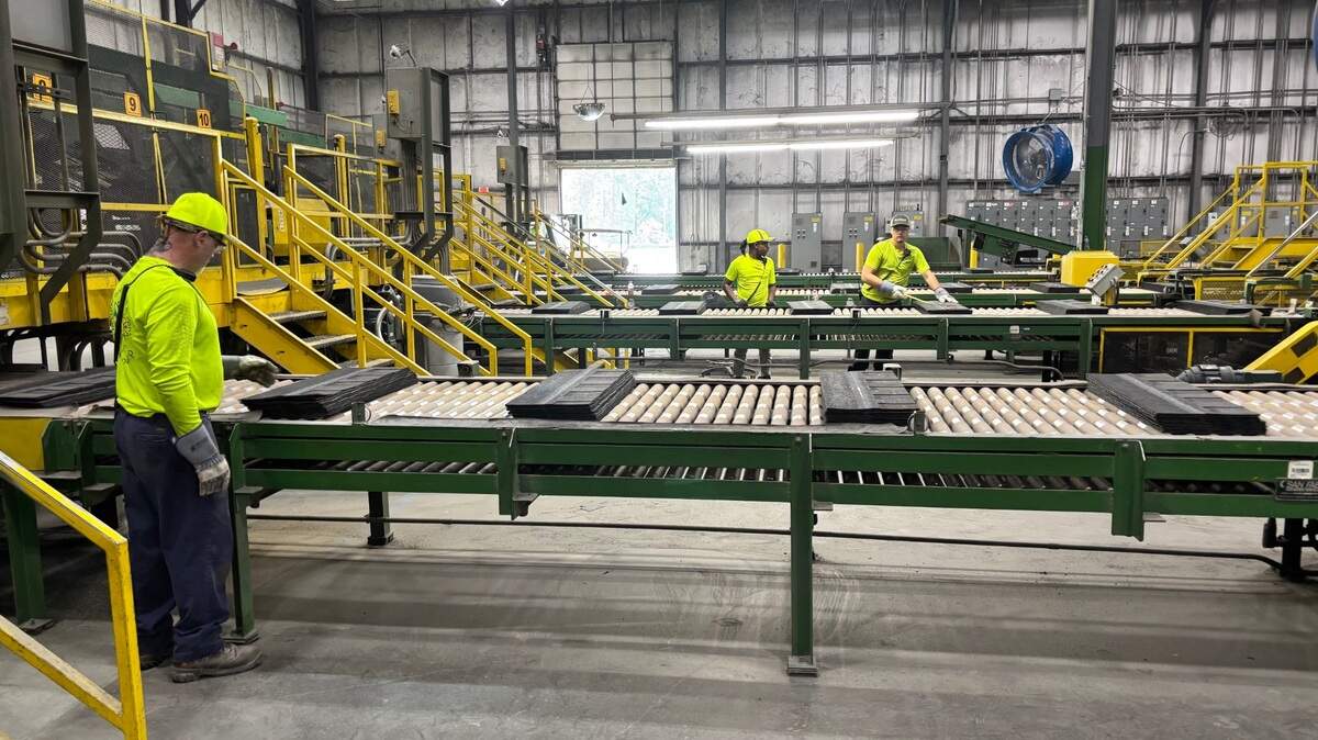 Workers produce roofing shingles at the CertainTeed plant in Oxford, NC on July 9, 2025.