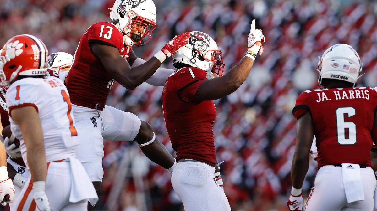 N.C. State linebacker Isaiah Moore (1) is congratulated by Tyler Baker-Williams (13) after a stop during the second half of N.C. State’s 27-21 overtime victory over Clemson at Carter-Finley Stadium in Raleigh, N.C., Saturday, Sept. 25, 2021.