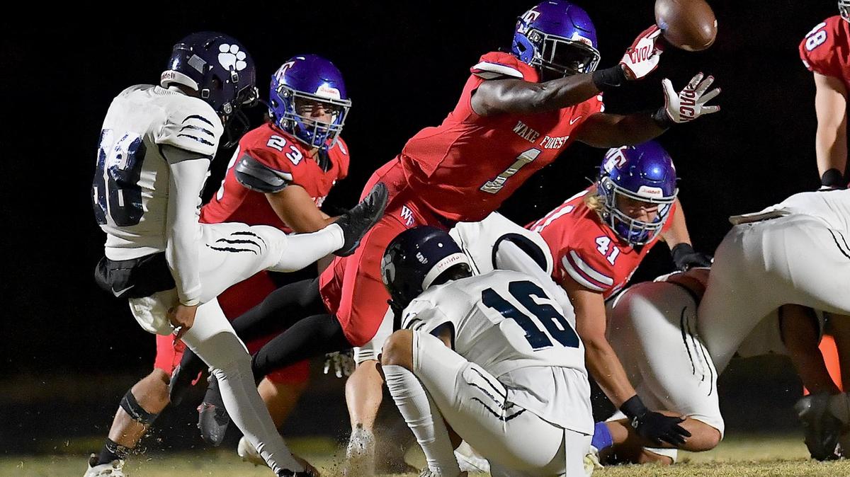 Wake Forest’s Nigel Lucas (1) deflects the field goal attempt by Millbrook kicker Angel Gomez-Corona during the first half. The Wake Forest Cougars and the Millbrook Wildcats met in a football game in Wake Forest, N.C. on October 28, 2022.