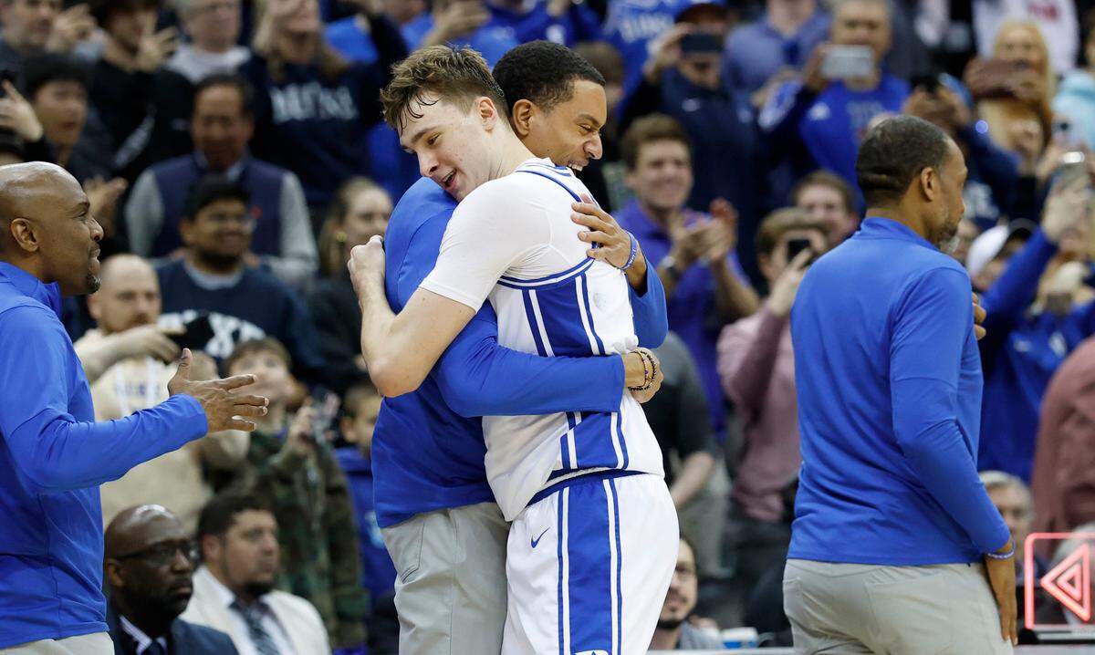 Duke director of player development Justin Robinson hugs Cooper Flagg as he comes off the court after Duke’s 85-65 victory over Alabama in their Elite Eight game in the 2025 NCAA Men’s Basketball Championship at the Prudential Center in Newark, N.J., Saturday, March 29, 2025.
