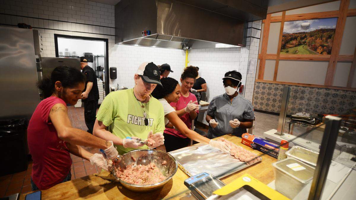 Preparing for the opening of the Old North State Food Hall, employees of Luna Pizza Cafe practice making meatballs. Luna is now working on a new location in downtown Clayton.