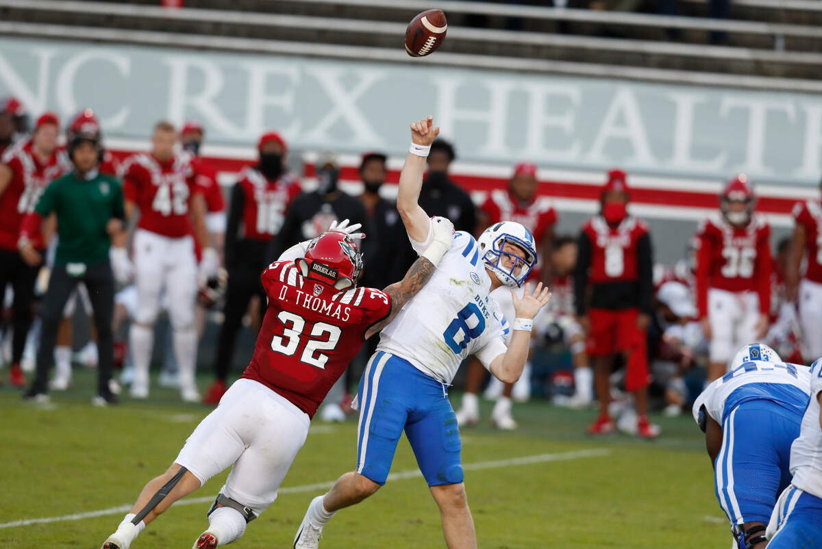 N.C. State linebacker Drake Thomas (32) hits Duke quarterback Chase Brice (8) as he throws, resulting in an interception by Payton Wilson during the second half of N.C. State’s 31-20 victory over Duke at Carter-Finley Stadium in Raleigh, N.C., Saturday, Oct. 17, 2020.
