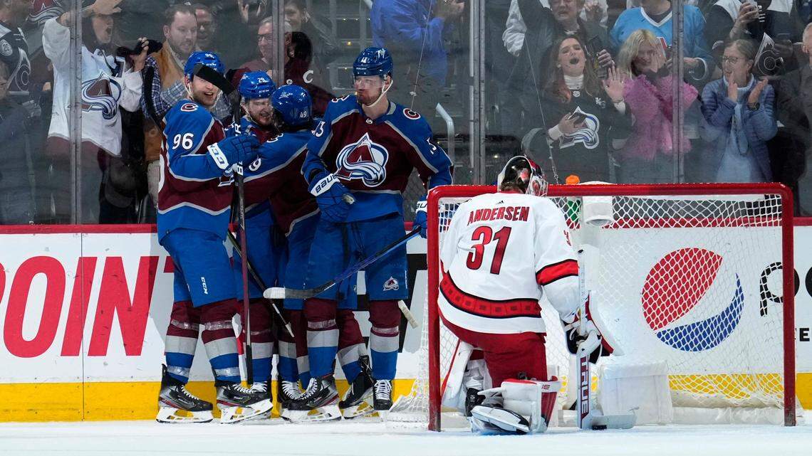 Colorado Avalanche center Nathan McKinnon, second from left, is congratulated by Mikko Rantanen (96), Samuel Girard (49) and Valeri Nichushkin (13) after against Carolina Hurricanes goaltender Frederik Andersen (31) during the third period of an NHL hockey game Saturday, April 16, 2022, in Denver. (AP Photo/Jack Dempsey)