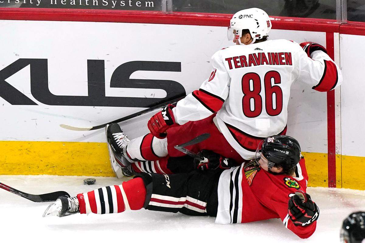 Carolina Hurricanes left wing Teuvo Teravainen, top, vies for the puck against Chicago Blackhawks center Matthew Highmore during the first period of an NHL hockey game in Chicago, Thursday, Feb. 4, 2021. (AP Photo/Nam Y. Huh)