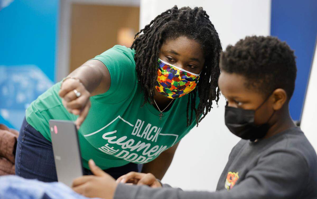 Anjané Jacobs, lead tutor, helps Kemar Wilson at the Emily K Center in Durham, N.C., Thursday, Feb. 24, 2022.