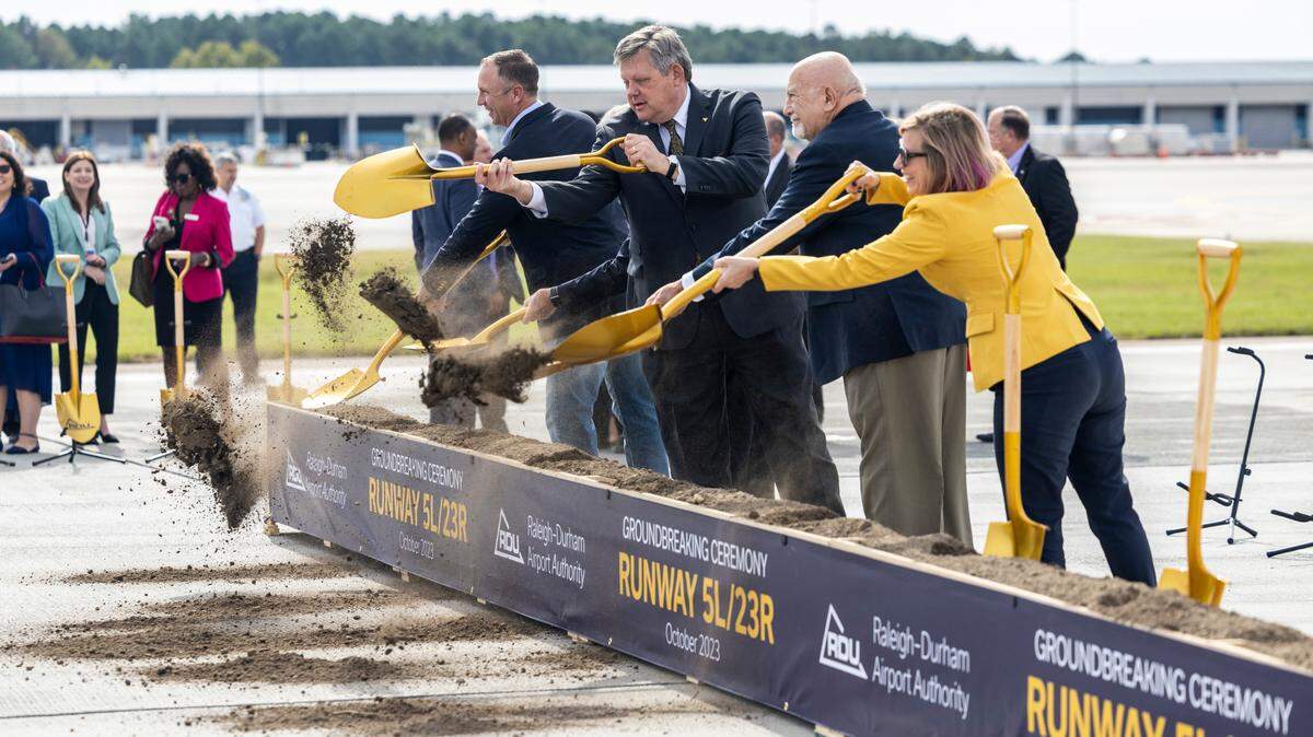 State legislators shovel dirt during a groundbreaking ceremony on runway 5L/23R at RDU International Airport in Morrisville, Wednesday, Oct. 11, 2023. A new, longer 5L/23R, will be built northwest and parallel to the existing runway near Terminal 2.