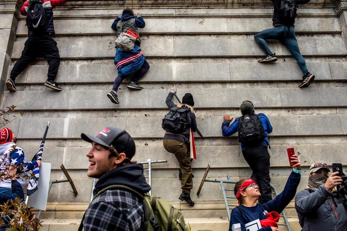 Protestors climb onto the Capitol in Washington on Wednesday, Jan. 6, 2021. The Capitol building was placed on lockdown, with senators and members of the House locked inside their chambers, as Congress began debating President-elect Joe BidenÕs victory. President Trump addressed supporters near the White House before protesters marched to Capitol Hill.