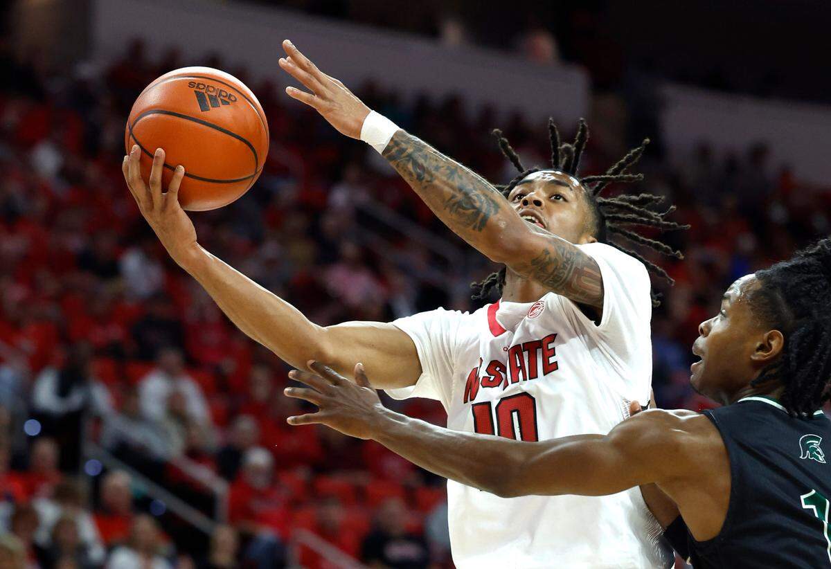 N.C. State’s Breon Pass (10) drives by Mount Olive’s Kennard Davis (11) during the first half of N.C. State’s exhibition game against Mount Olive at PNC Arena in Raleigh, N.C., Wednesday, Nov. 1, 2023.