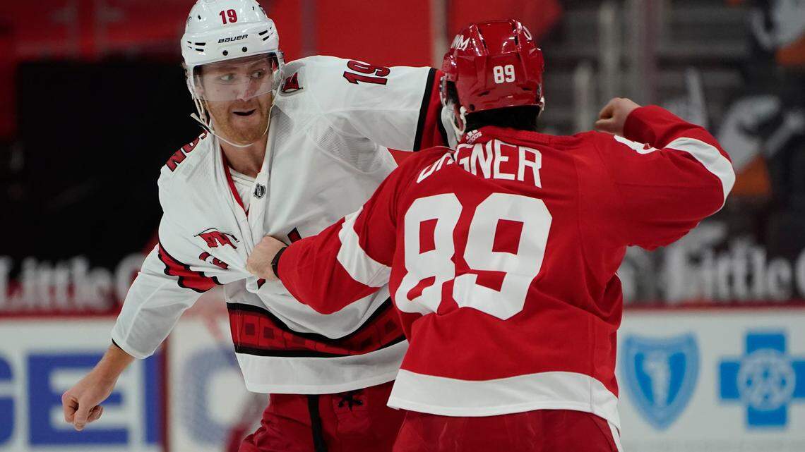 Carolina Hurricanes defenseman Dougie Hamilton (19) and Detroit Red Wings center Sam Gagner (89) fight in the second period of an NHL hockey game Thursday, Jan. 14, 2021, in Detroit. (AP Photo/Paul Sancya)