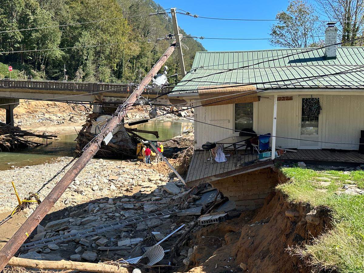 A house now hangs precariously over the Rocky Broad River just upstream of the U.S. 64 bridge in Bat Cave, North Carolina. Taken Thursday, Oct. 10, 2024.