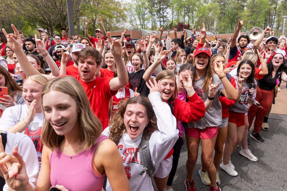 NC.State fans cheer as a bus carrying the men’s basketball team departs campus Wednesday, April 3, 2024. The team is headed to the Final Four for the first time since 1983.
