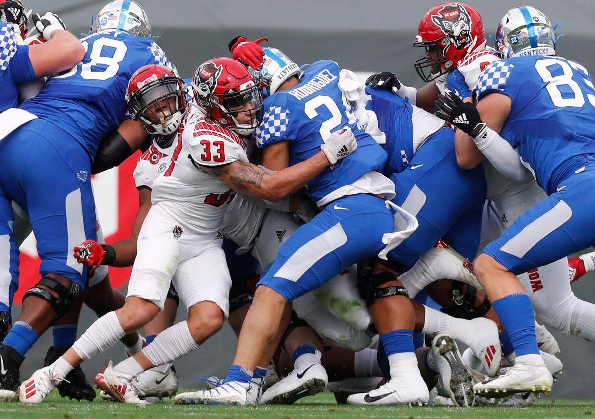 N.C. State’s N.C. State’s Isaac Duffy (33) stops Kentucky’s Chris Rodgriguez Jr. for a loss on a during the first half of N.C. StateÕs game against Kentucky in the Gator Bowl at TIAA Bank Field in Jacksonville, Fla., Saturday, January 2, 2021.