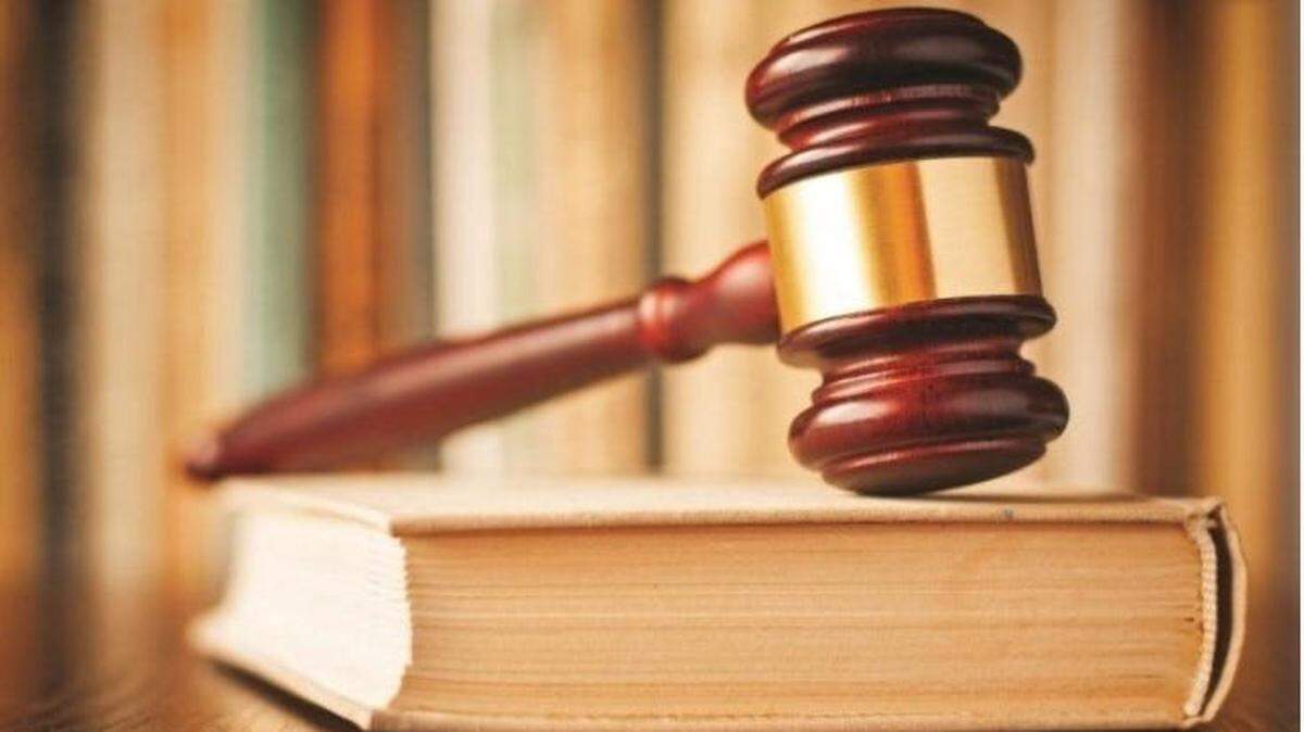 A judge’s gavel rests on a book of law.