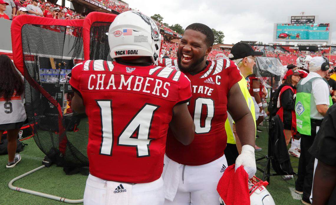 N.C. State center Grant Gibson (50) celebrates with quarterback Jack Chambers (14) after Chambers threw a touchdown pass during the second half of N.C. State’s 55-3 victory over Charleston Southern at Carter-Finley Stadium in Raleigh, N.C., Saturday, Sept. 10, 2022.