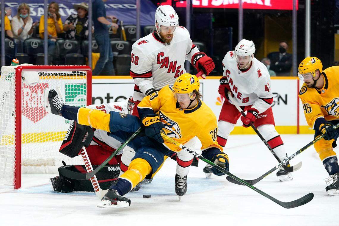 Nashville Predators right wing Eeli Tolvanen (28) collides with Carolina Hurricanes defenseman Jani Hakanpaa (58) in front of the net during the second period in Game 3 of an NHL hockey Stanley Cup first-round playoff series Friday, May 21, 2021, in Nashville, TN.