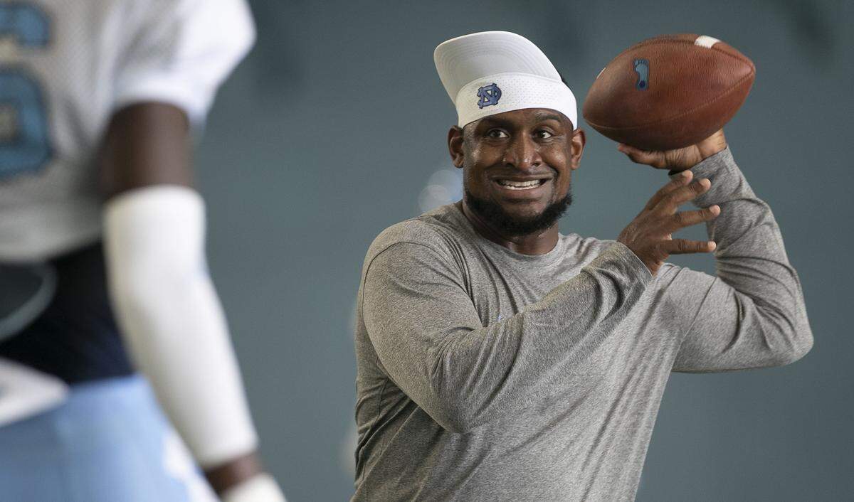 North Carolina cornerbacks coach Dre Bly passes the ball to D.J. Ford (16) during the Tar Heels practice on Tuesday, August 6, 2019 at the Football Practice Facility in Chapel Hill, N.C.