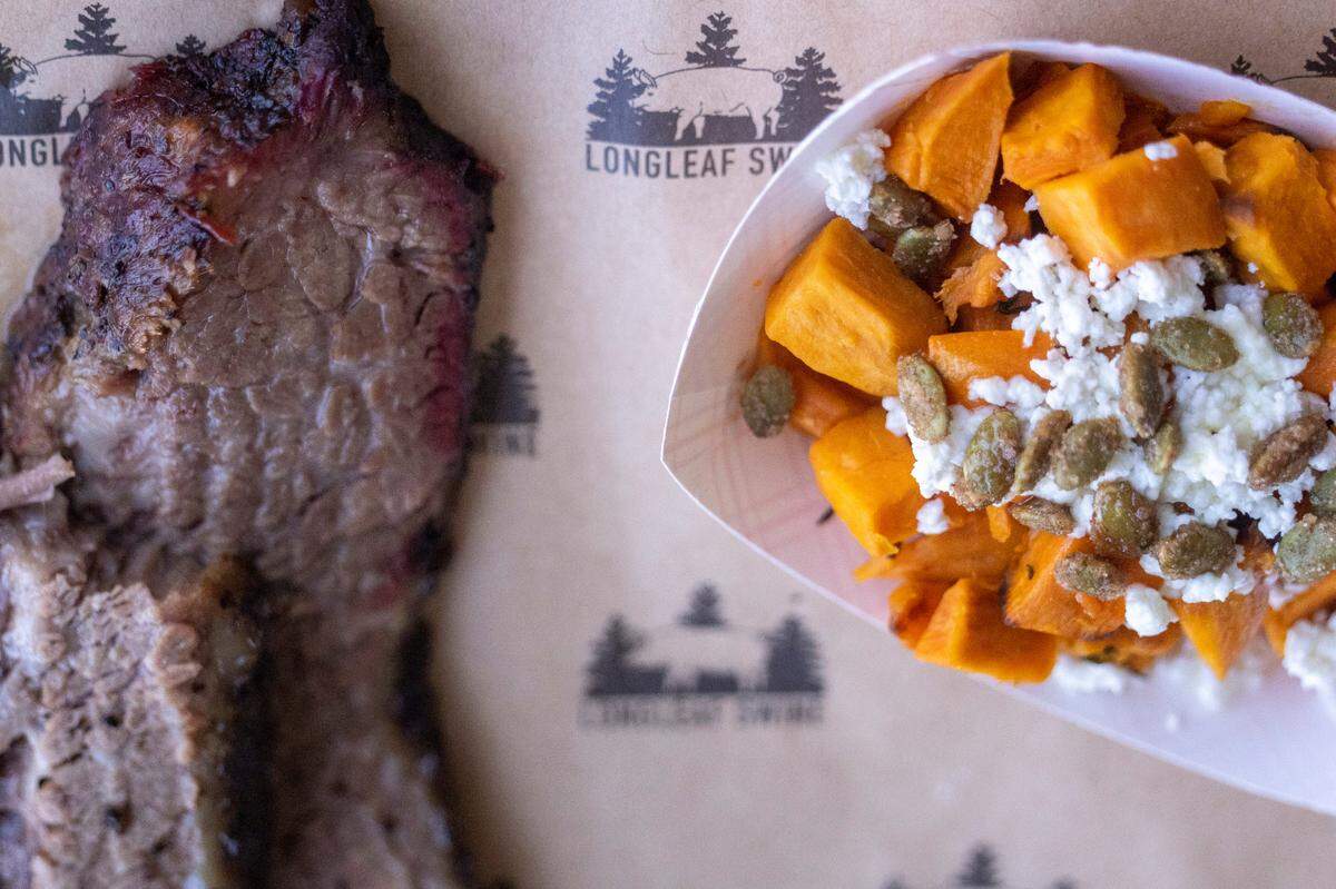 Brisket and sweet potatoes sit on a tray during the opening of Longleaf Swine in Raleigh Friday, Nov. 4, 2022.