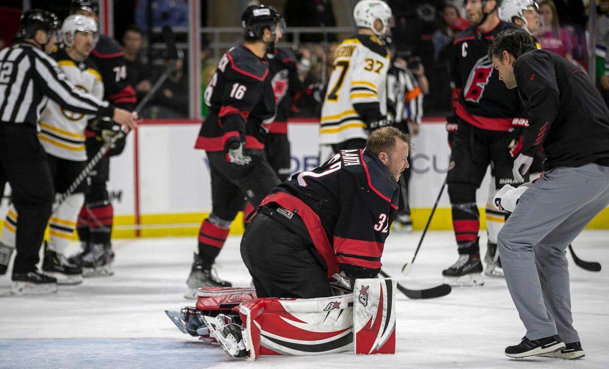 Carolina Hurricanes goalie Antii Raanta (32) rises to his knees after being hit from behind by Boston Bruins David Pastrnak (88) in the first period on Wednesday, May 4, 2022 during game two of their Stanley Cup first round series at PNC Arena in Raleigh, N.C. Antii was injured left the game.